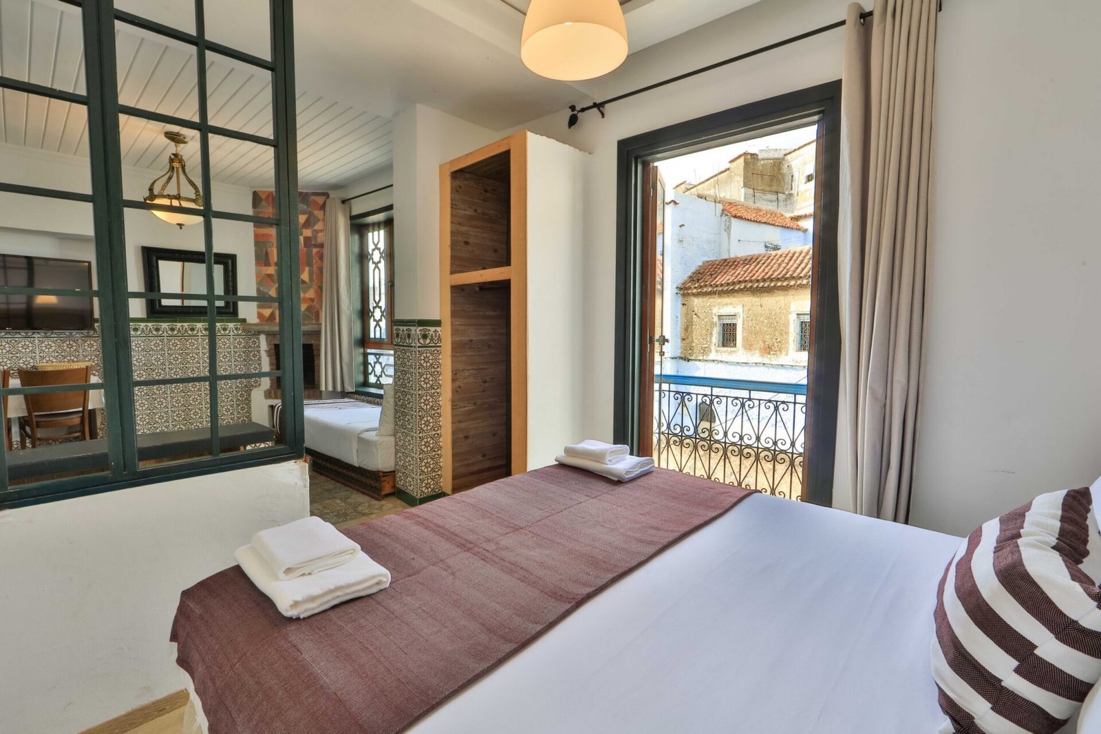 Interior de un alojamiento de Casa Rita, con azulejos tradicionales, cama y ventana con vistas a Chefchaouen.